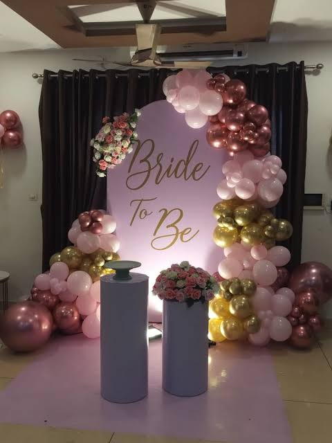 Elegant bridal shower decor with floral wall and lounge chairs